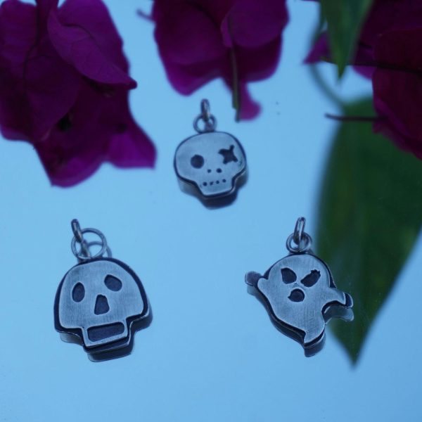 Handcrafted sterling silver skull and ghost pendants featuring playful designs: Boo Buddy, Wink and a Hex, and Grinning Ghoul. Perfect for spooky jewelry lovers.