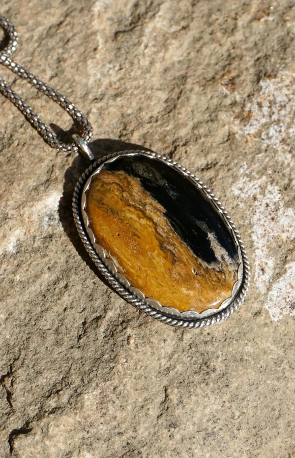 Handcrafted Palm Root Agate pendant in sterling silver with earthy brown and black brushstroke patterns, featuring a unique pumpkin-inspired cutout on the back