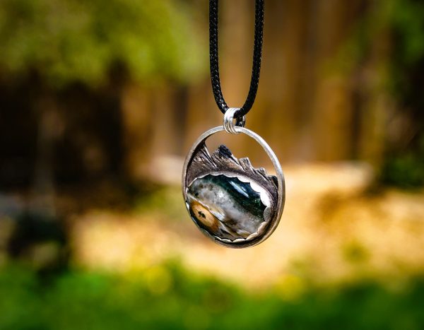 Sterling silver pendant with ocean jasper hanging from the right side, showcasing mountain texture.