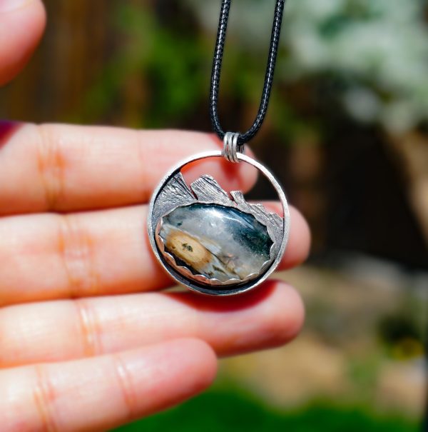 cean jasper mountain pendant shown resting on hand for size reference.