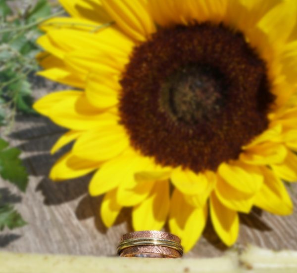 Copper spinner rings next to sunflower
