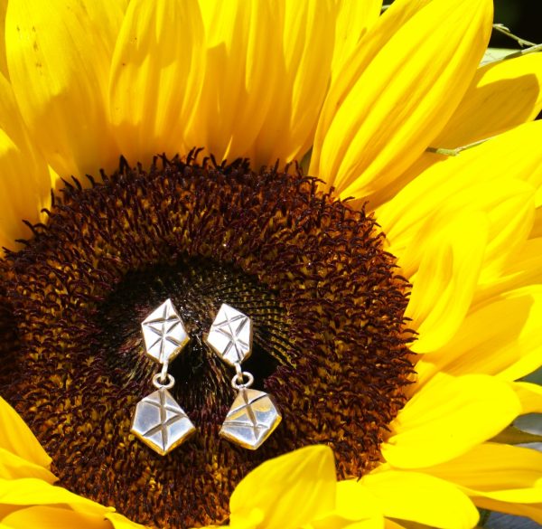 Close up Geometric Link Drop Stud Earrings displayed on sunflower for natural jewelry photography