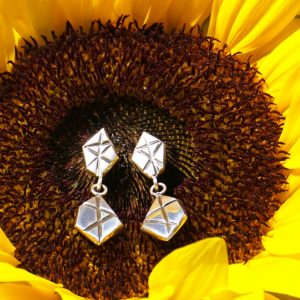 Close up Geometric Link Drop Stud Earrings displayed on sunflower for natural jewelry photography
