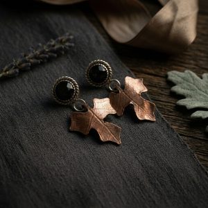obsidian copper leaf earrings laid on textured cloth