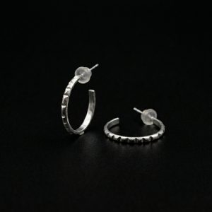 Sterling silver half hoop earrings with chocolate shard texture on black background