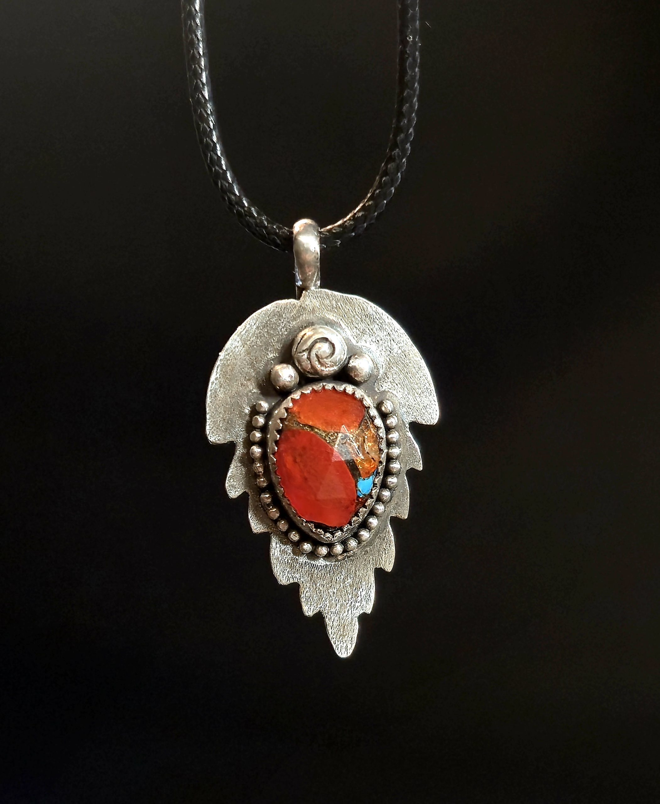 Silver Leaf Pendant Necklace hanging on black nylon cord, orange and turquoise composite stone, handcrafted sterling silver leaf backplate with beaded edges