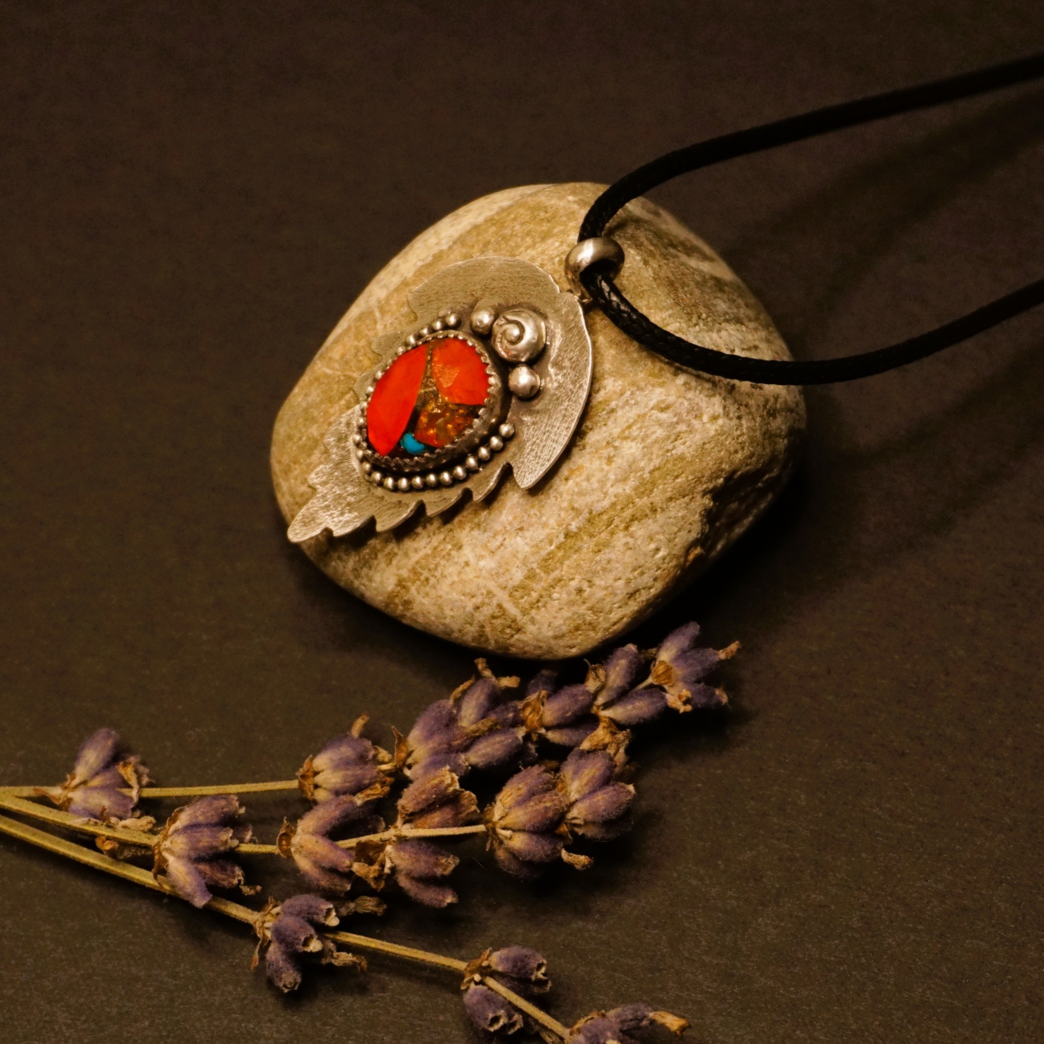 Left side view of Solstice Leaf Pendant Necklace, showing bezel-set orange and turquoise composite stone and textured leaf-shaped sterling silver backplate with beaded edges