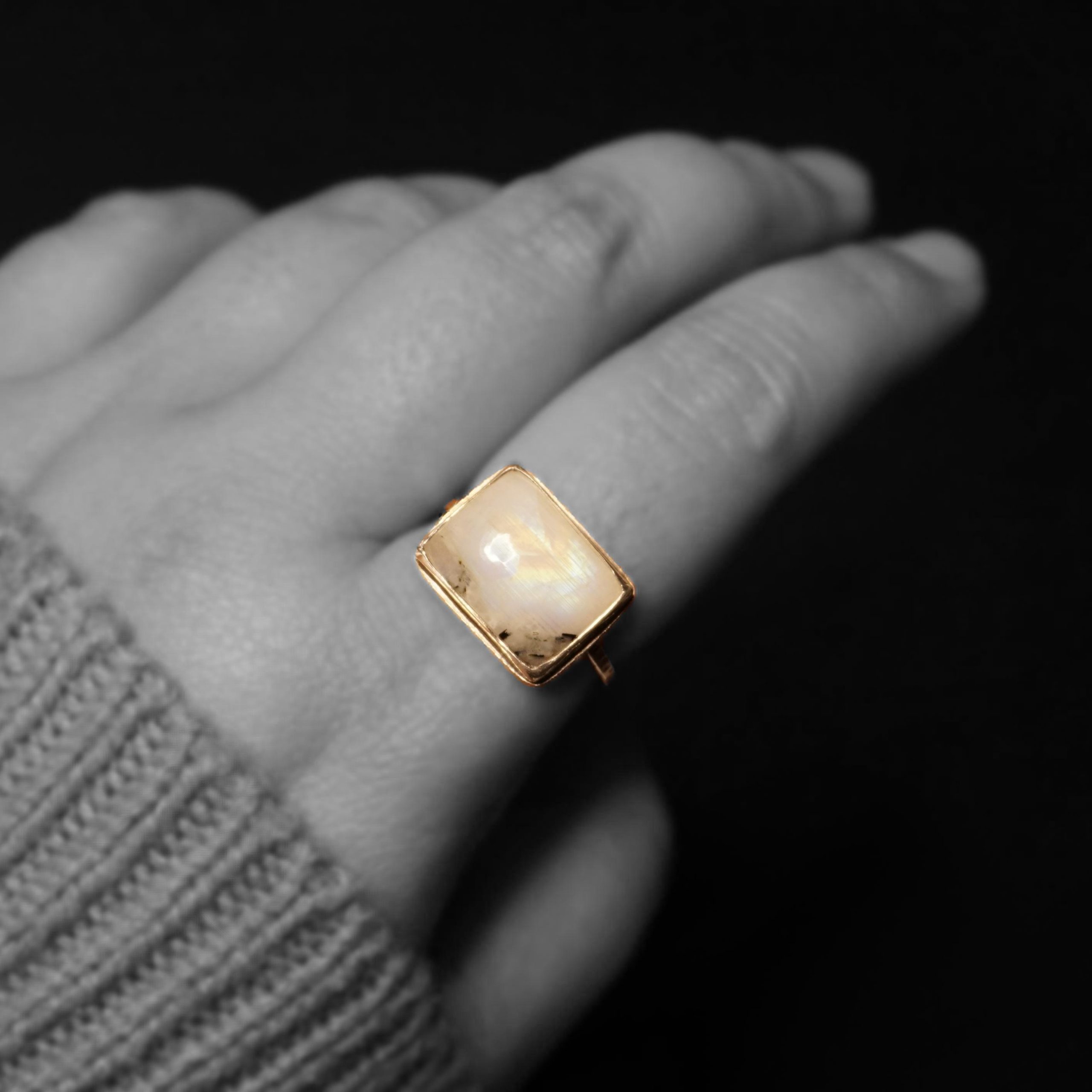 Square moonstone silver ring close-up, black & white hand